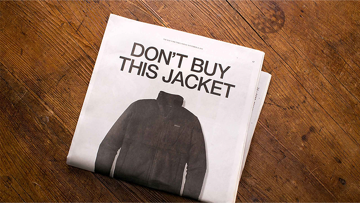 newspaper on the wooden floor showing a patagonia jacket, headline reads don't buy this jacket