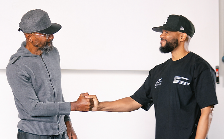 photo of ARCHTOCULTURE Creative Agency Founders Damon White and brand strategist Kyle Frazier shaking hands