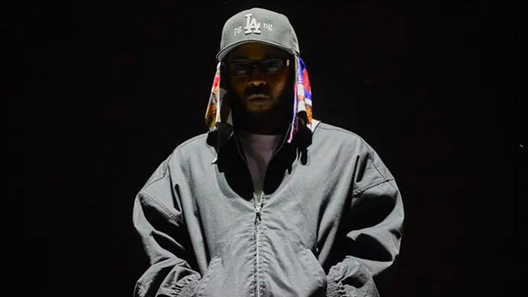 Kendrick Lamar - standing, representing contemporary hip-hop culture.